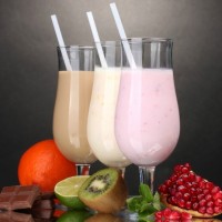 Milk shakes with fruits and chocolate on grey background